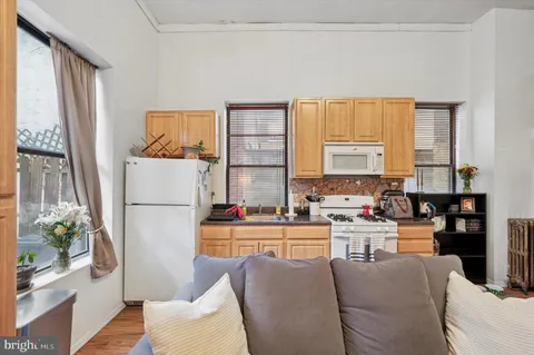a living room with furniture a large window and kitchen view