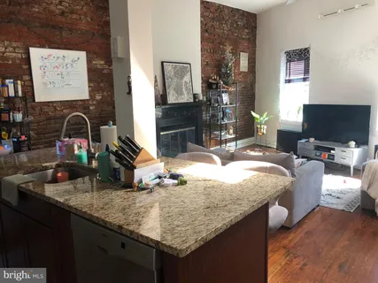 a kitchen with sink and view of living room
