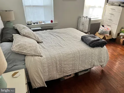 a bedroom with a bed and wooden floor