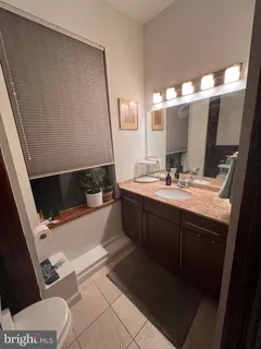 a bathroom with a sink a toilet a mirror and shower