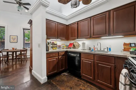 a kitchen with stainless steel appliances granite countertop a stove a sink dishwasher and cabinets with wooden floor