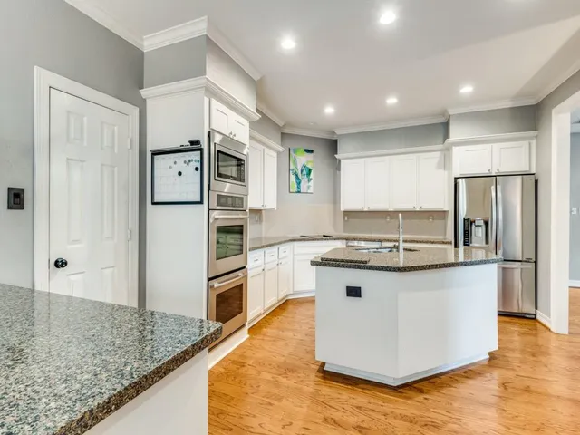a kitchen with stainless steel appliances granite countertop a refrigerator and a sink