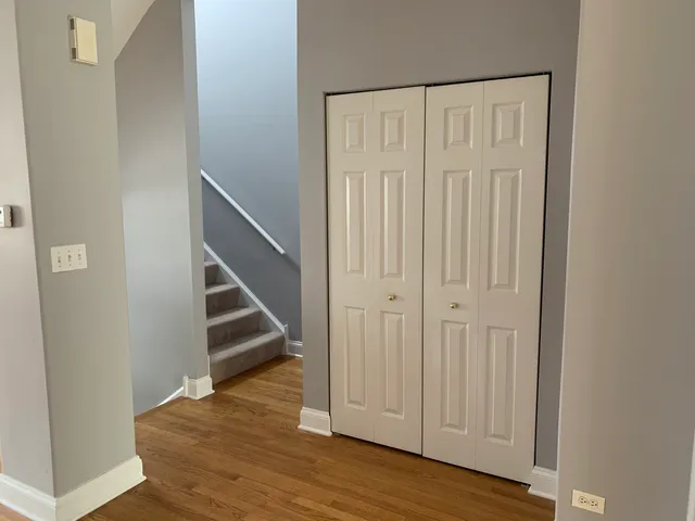 an empty room with wooden floor and entryway