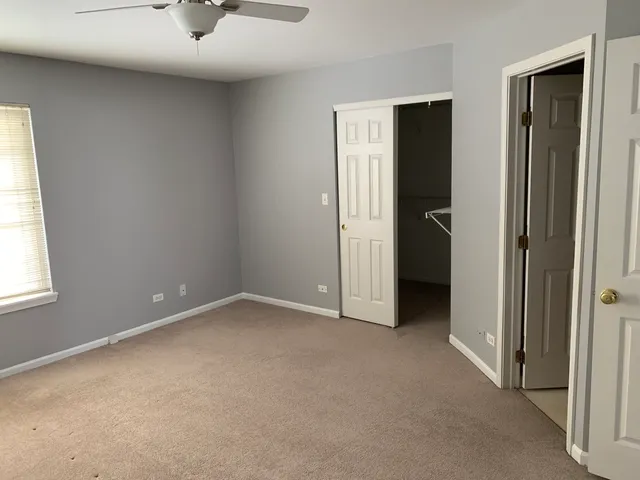an empty room with a window and a bathroom