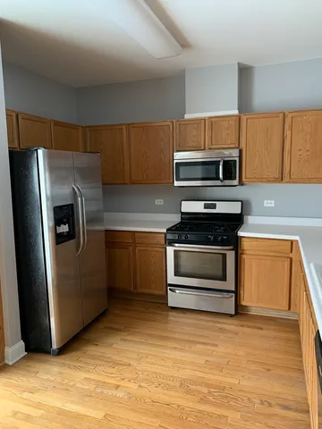 a kitchen with kitchen island granite countertop a stove cabinets and wooden floor