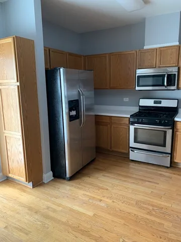 a kitchen with stainless steel appliances granite countertop a refrigerator a stove and a sink