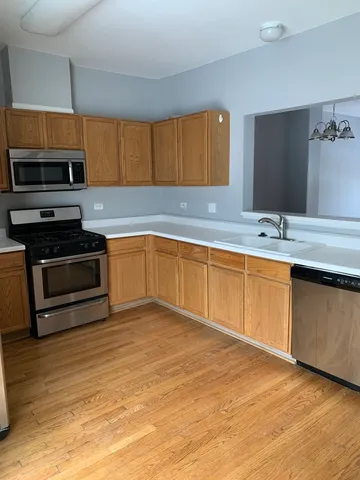 a kitchen with stainless steel appliances granite countertop a sink and a stove