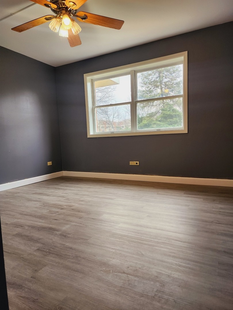 1450 Wing Street, Unit 2B Elgin, IL 60123 - Photo 4 of 17 an empty room with wooden floor and windows