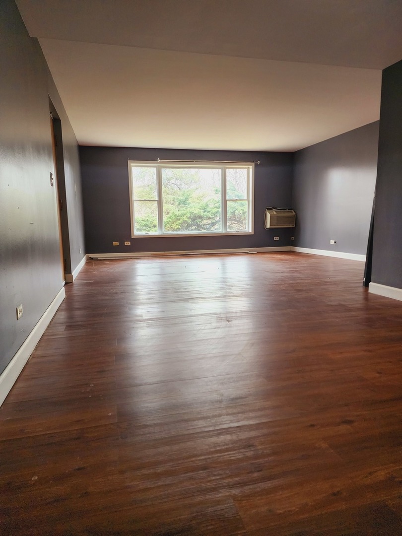 1450 Wing Street, Unit 2B Elgin, IL 60123 - Photo 8 of 17 a view of empty room with wooden floor and fan