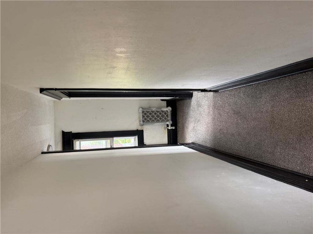 41 West Ridge Street Lansford, PA 18232 - Photo 29 of 40 A well-lit landing area offers a glimpse of the lower level, with a window providing natural light.