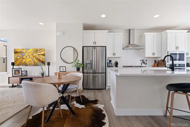 a kitchen with a table chairs refrigerator and microwave