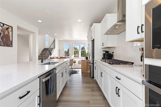 a kitchen with stainless steel appliances a sink stove and cabinets