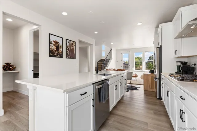 a kitchen with stainless steel appliances kitchen island granite countertop a stove and a sink