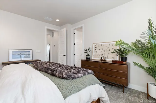 a bedroom with a bed and a potted plant