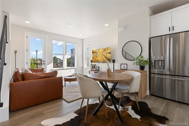 a living room with furniture a large window and kitchen view