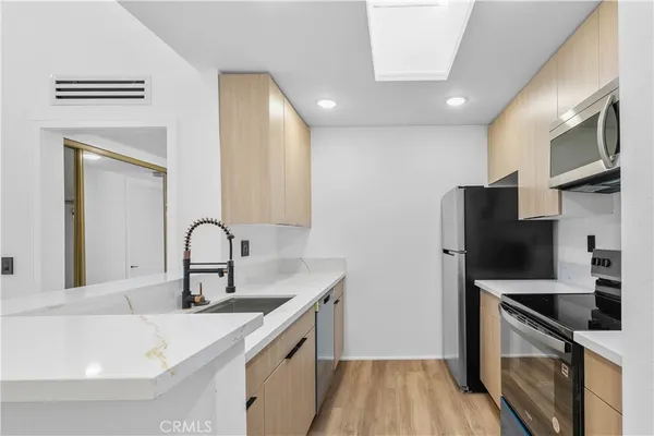 a kitchen with stainless steel appliances a sink stove and refrigerator
