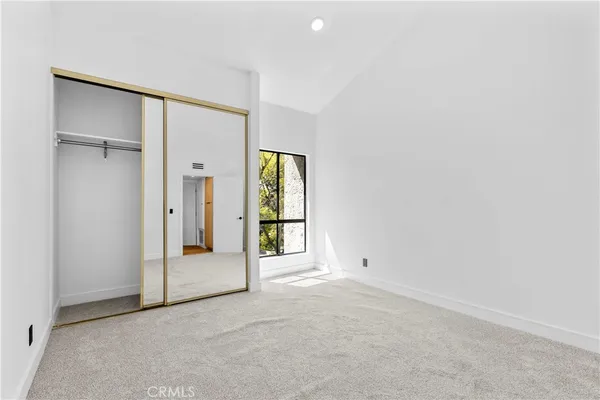 an empty room with windows and closet
