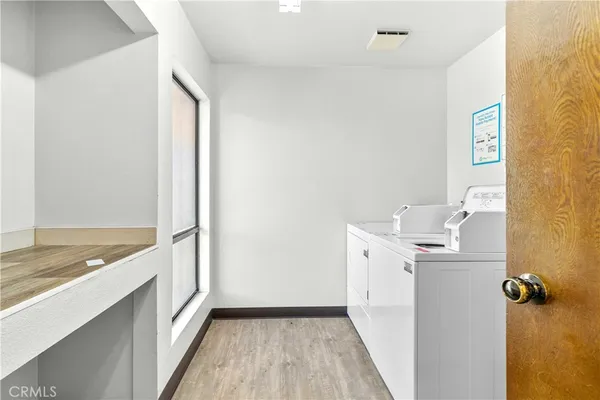 a view of a hallway with a closet and wooden floor