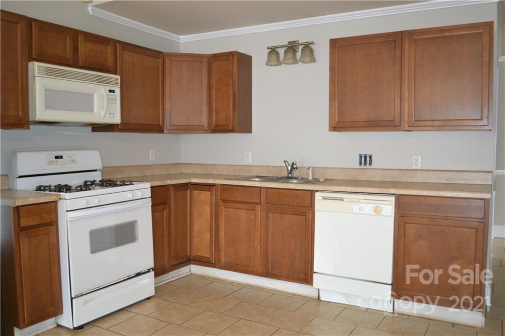 489 Union Cemetery Road Southwest Concord, NC 28027 - Photo 6 of 19 a kitchen with stainless steel appliances granite countertop a sink stove and microwave