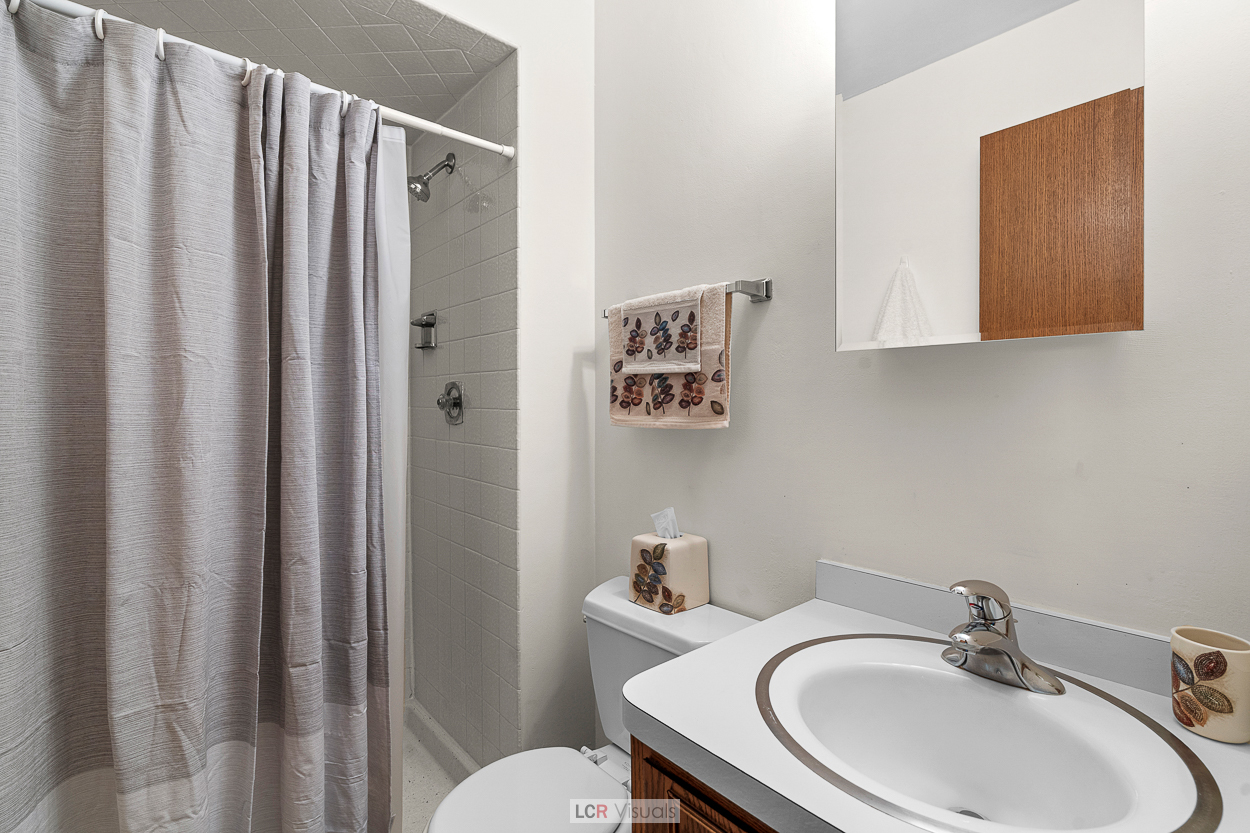 7616 West Lawrence Avenue, Unit 2B Harwood Heights, IL 60706 - Photo 9 of 15 a bathroom with a sink a toilet and shower curtain