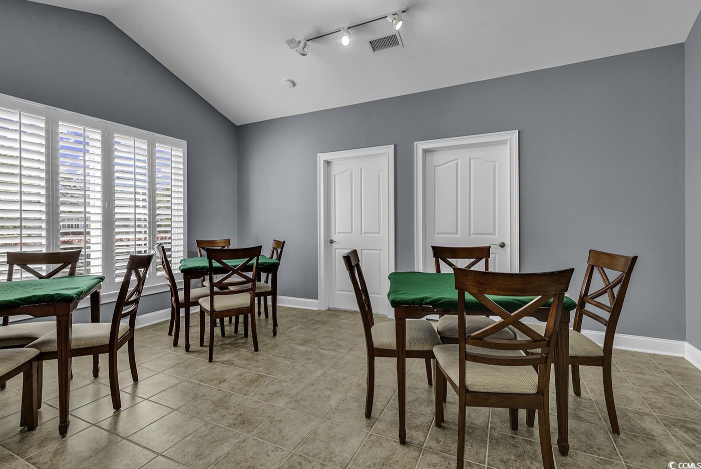 109 Stonegate Boulevard, Unit 109 Murrells Inlet, SC 29576 - Photo 33 of 39 Dining space featuring vaulted ceiling, rail light