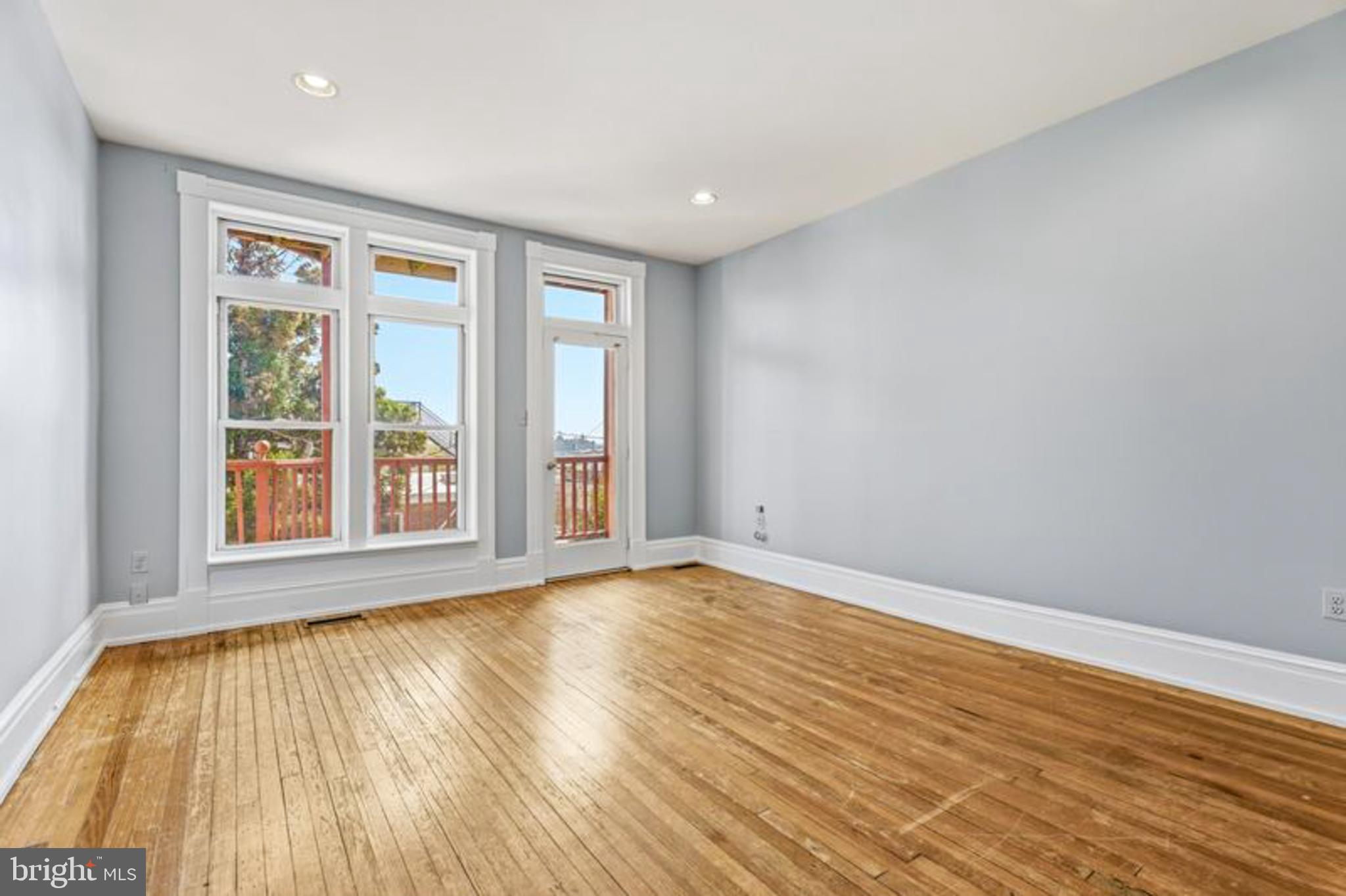 2033 East Pratt Street Baltimore, MD 21231 - Photo 27 of 61 a view of an empty room with wooden floor and a window