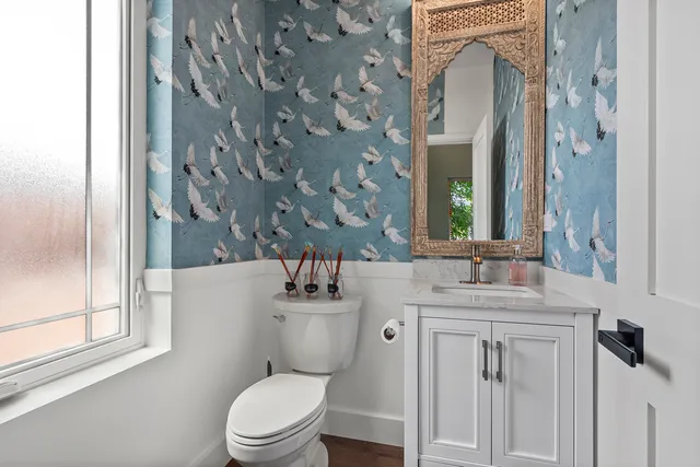 a bathroom with a granite countertop toilet sink and mirror