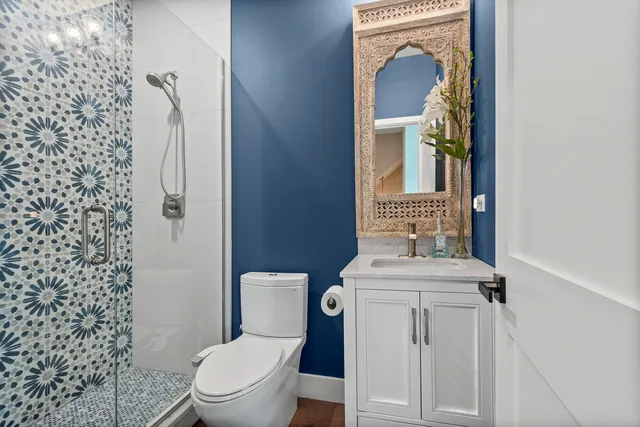 a bathroom with a toilet sink vanity and mirror