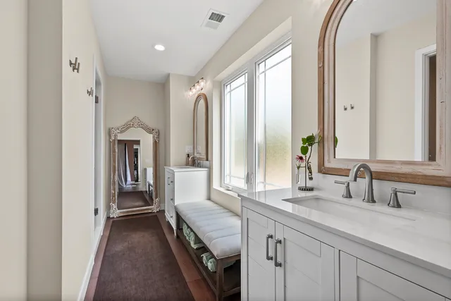 a en suite bathroom with a granite countertop sink and a mirror