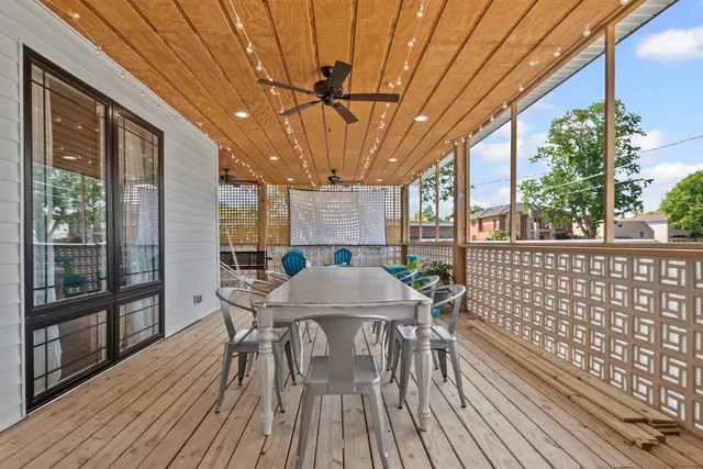 a view of a patio with table and chairs a barbeque with wooden floor and fence