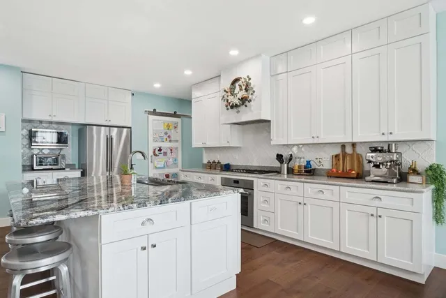 a kitchen with stainless steel appliances granite countertop a sink and cabinets