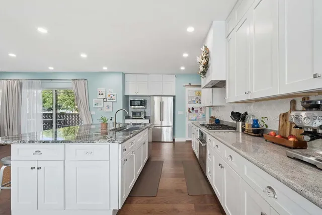 a kitchen with stainless steel appliances granite countertop a sink stove and cabinets
