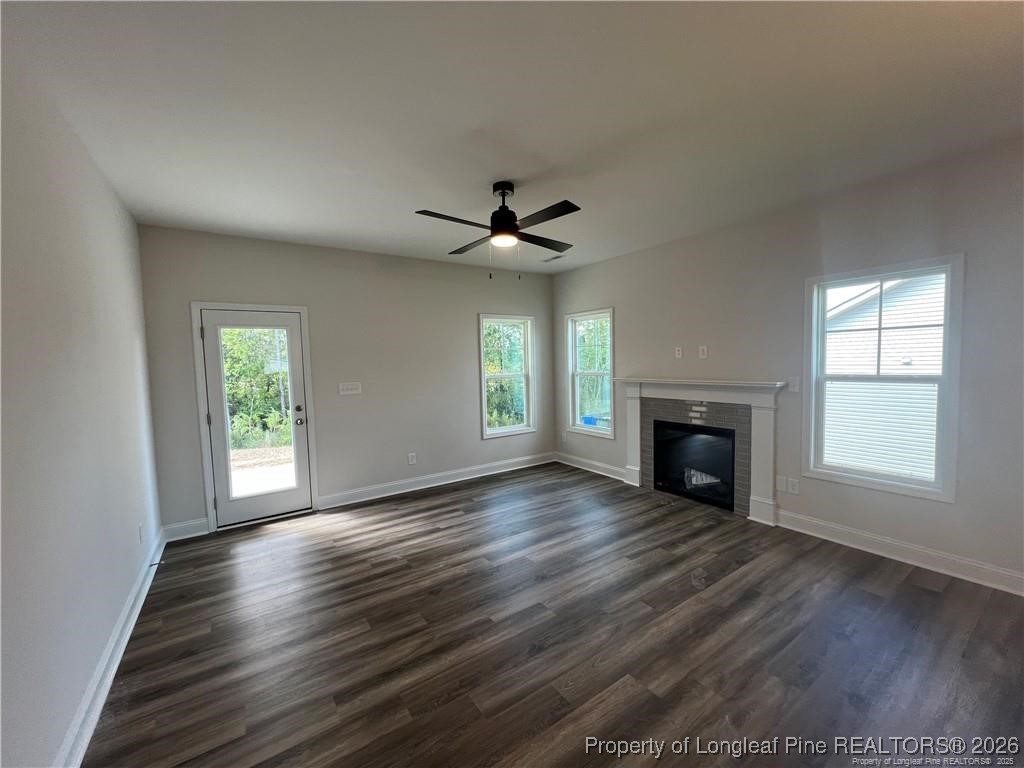 3870 Blackhills Road Fayetteville, NC 28311 - Photo 20 of 22 an empty room with wooden floor fireplace and windows