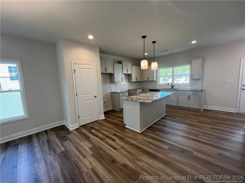 3870 Blackhills Road Fayetteville, NC 28311 - Photo 5 of 22 a large kitchen with granite countertop a stove top oven a sink dishwasher and a fireplace with wooden floor