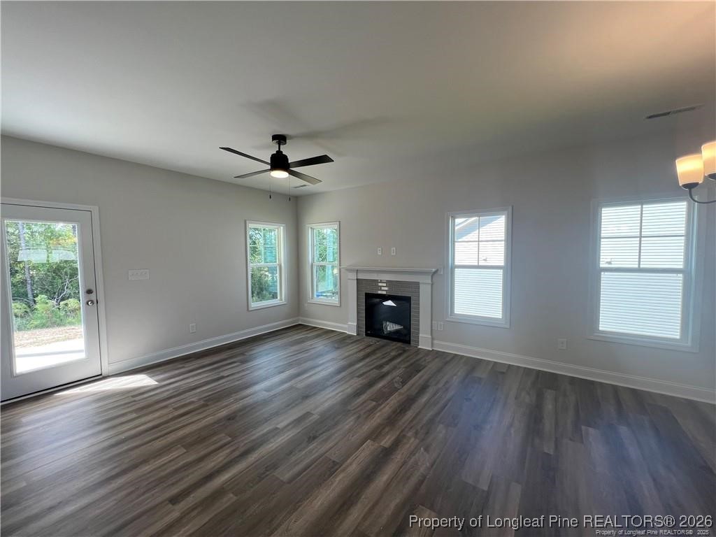 3870 Blackhills Road Fayetteville, NC 28311 - Photo 8 of 22 an empty room with wooden floor fireplace and windows