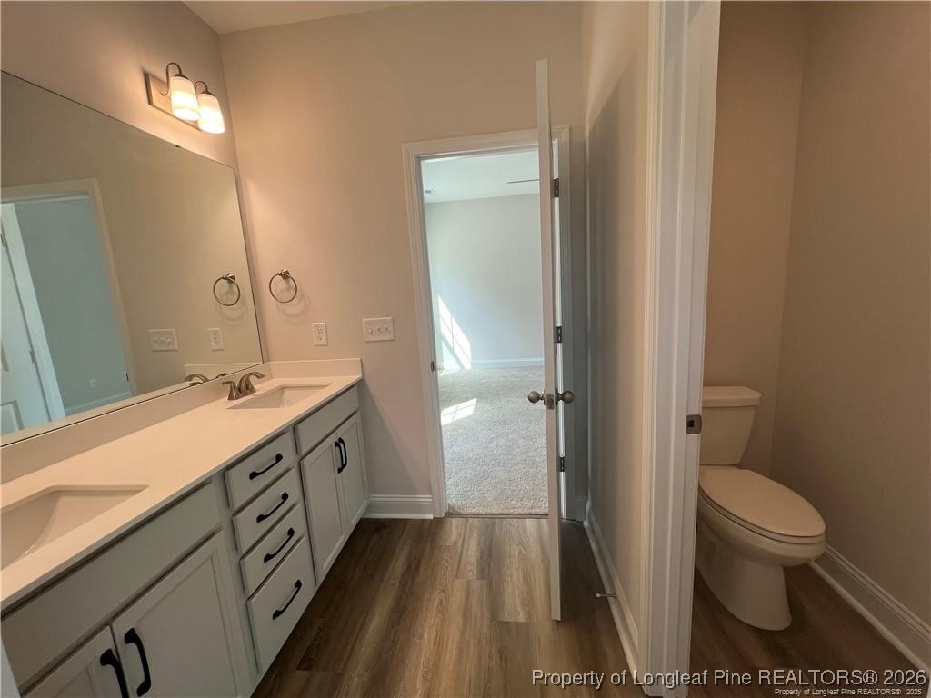 3870 Blackhills Road Fayetteville, NC 28311 - Photo 10 of 22 a spacious bathroom with a double vanity sink a toilet and a mirror