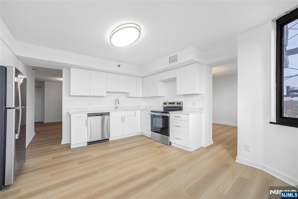 316 Prospect Avenue, Unit 4E Hackensack, NJ 07601 - Photo 7 of 19 a kitchen with white cabinets and white appliances