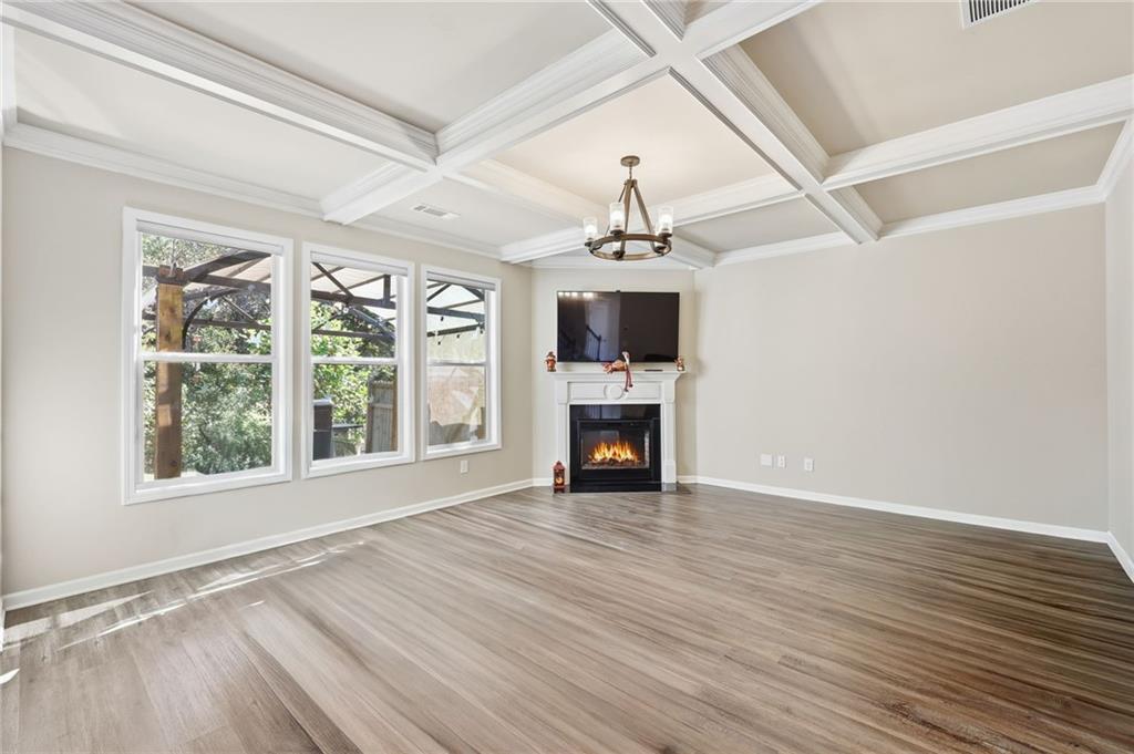 3247 Hawthorne Path Braselton, GA 30517 - Photo 18 of 44 a view of empty room with wooden floor and fireplace