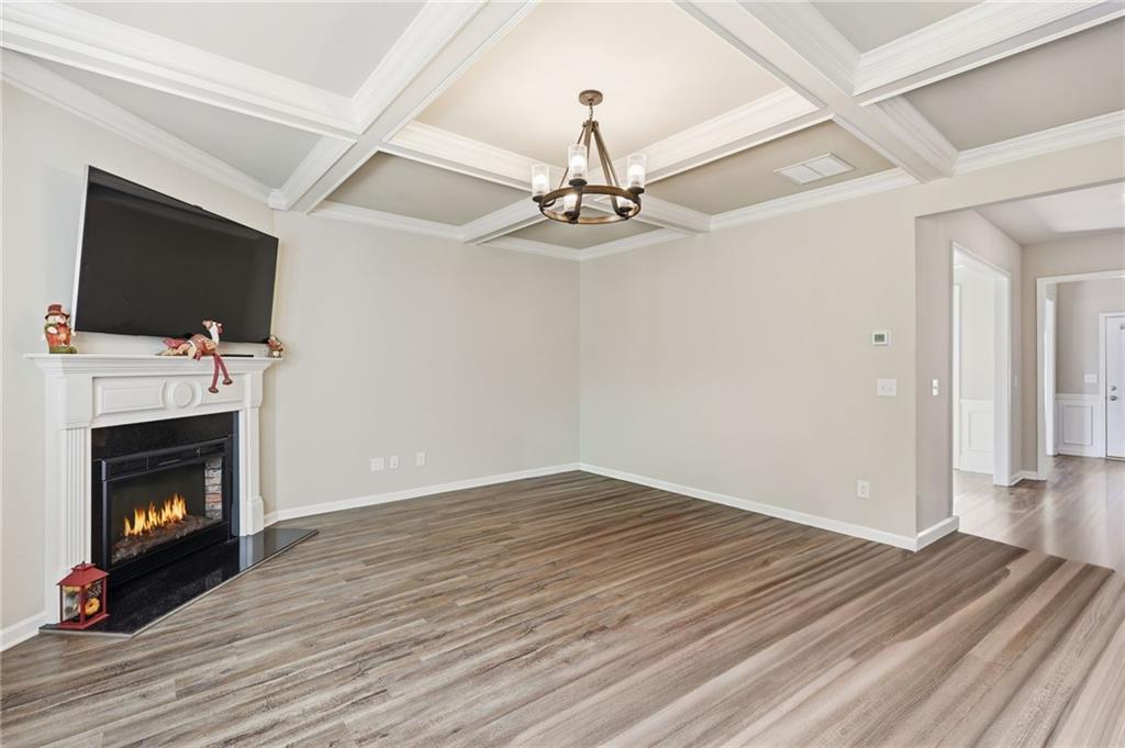 3247 Hawthorne Path Braselton, GA 30517 - Photo 20 of 44 a view of an empty room with wooden floor fireplace and a window