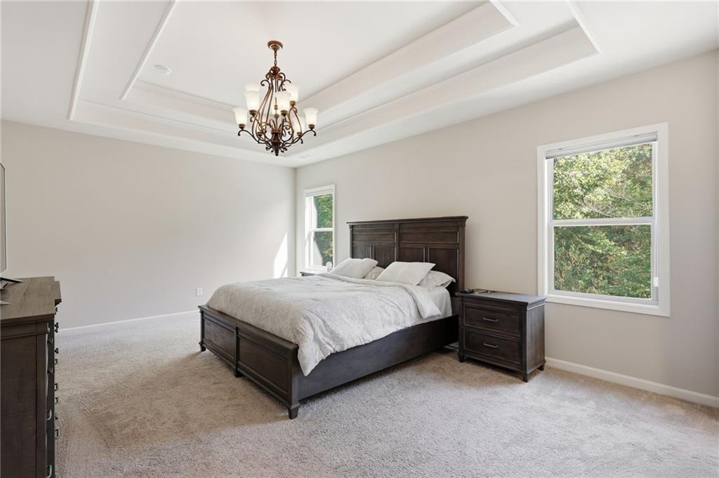 3247 Hawthorne Path Braselton, GA 30517 - Photo 23 of 44 a spacious bedroom with a bed and a window