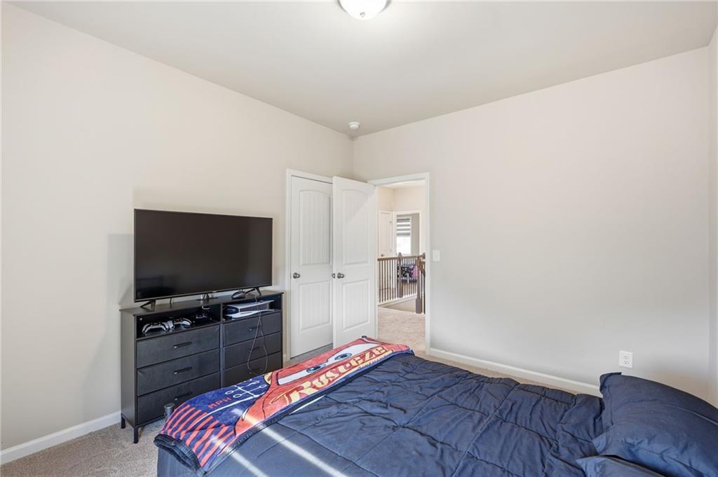 3247 Hawthorne Path Braselton, GA 30517 - Photo 29 of 44 a bedroom with a bed and a flat screen tv