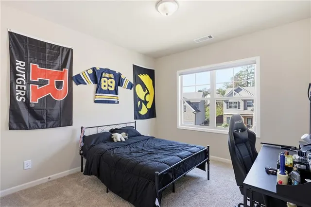 a bedroom with a bed and painting on the wall