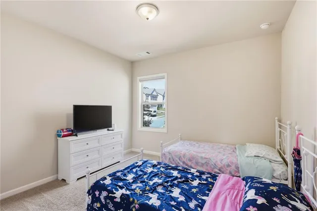 a bedroom with a bed and a flat tv screen on the dresser