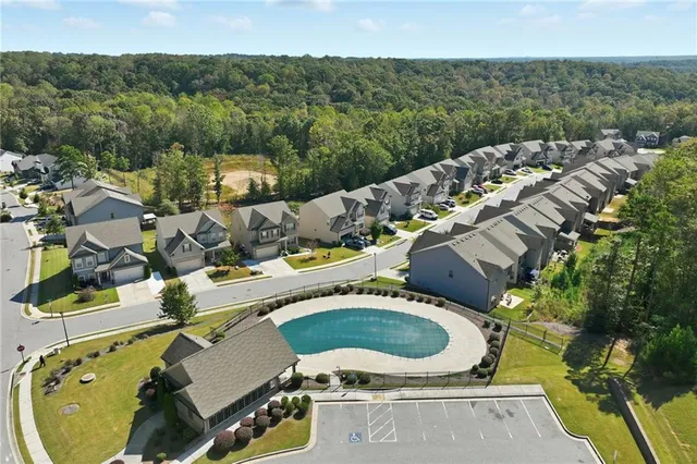 an aerial view of a house with a swimming pool and lake view