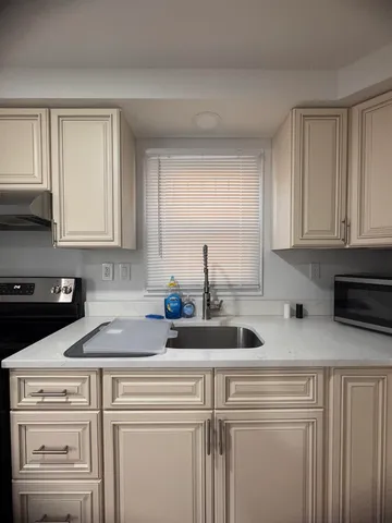 a kitchen with white cabinets and white appliances