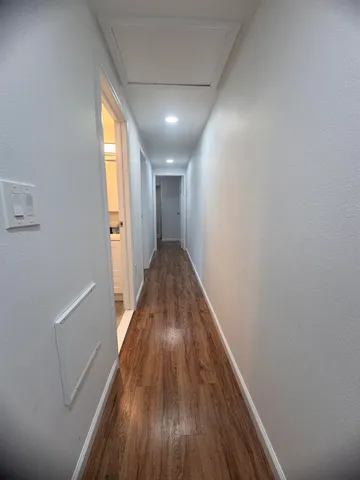 a view of hallway with wooden floor