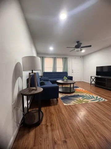 a living room with furniture and a wooden floor