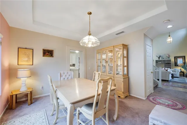a view of a dining room with furniture and a chandelier