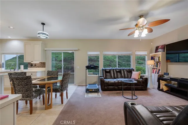 a living room with furniture a flat screen tv and a large window