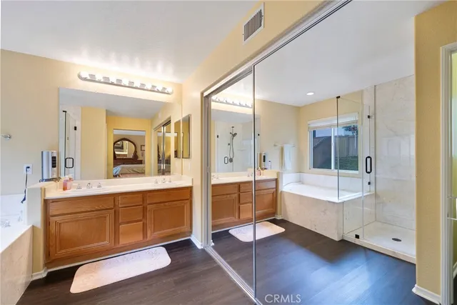 a bathroom with a double vanity sink toilet mirror and bathtub